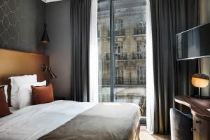 ein Hotelzimmer mit einem Bett und einem großen Fenster in der Unterkunft CasaÔ in Paris