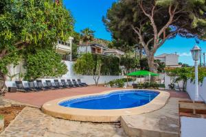 モライラにあるPedro - two story holiday home villa in El Portetの椅子と木々のある庭のスイミングプール