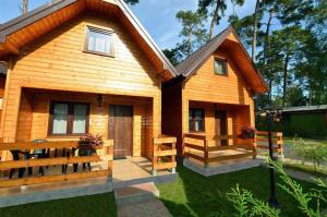 a small wooden house with a porch and a patio at Ośrodek 9Amber in Pobierowo