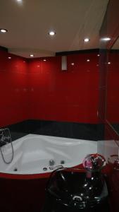 a red bathroom with a tub and a sink at Apartament u Jawora in Grywałd