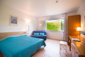 アンティーブにあるvilla "Les Cactees" Petite résidence de tourisme classée 3 étoilesのベッドルーム1室(ベッド1台、椅子、窓付)