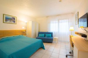 アンティーブにあるvilla "Les Cactees" Petite résidence de tourisme classée 3 étoilesのベッドルーム(青いベッド1台、青い椅子付)
