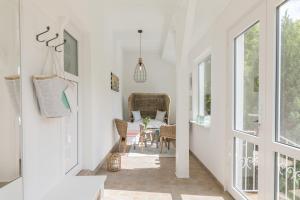 a hallway with white walls and a table and chairs at Boddenhaus Darss in Wieck