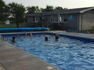 a group of children swimming in a swimming pool at Dreamweavers Cottages and Home Place Vacation Home in Rustico