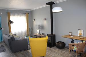 a living room with a table and a yellow chair at Lost in Terceira in Angra do Heroísmo