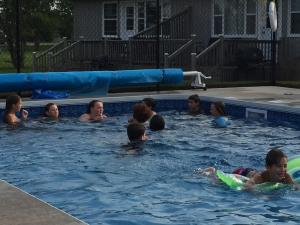 un grupo de personas en una piscina en Dreamweavers Cottages and Home Place Vacation Home, en Rustico