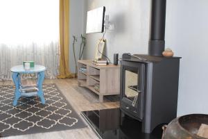 a living room with a wood stove and a stool at Lost in Terceira in Angra do Heroísmo