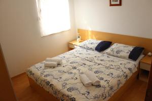 a bedroom with a bed with two towels on it at Apartments Mustač in Drage