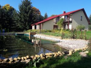 una casa y un estanque frente a una casa en Apartamenty Kama, en Polanica-Zdrój