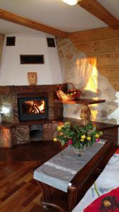 a living room with a fireplace and a table with flowers at Apartament u Jawora in Grywałd