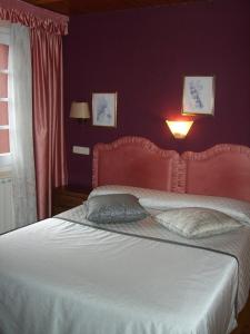 a bedroom with a large bed with a red wall at Aero Hotel Cerdanya Ca L'eudald in Alp