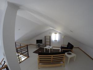 ein Wohnzimmer mit einem Sofa und einem Tisch in der Unterkunft Aldeia da Encosta in Velas