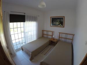 - une chambre avec un lit et une fenêtre dans l'établissement Aldeia da Encosta, à Velas