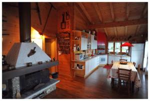 a kitchen and dining room with a fireplace in a cabin at Villa Tirolese in Due Cossani