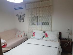 a bedroom with a bed and a butterfly on the window at Tiberias Vacation Rental in Tiberias