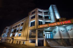 un edificio de hotel con un cartel de prestigio por la noche en Prestige Boutique Hotel Craiova en Craiova