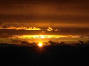 un tramonto tra le nuvole con il sole all'orizzonte di I Quattro Gatti a Gabiano