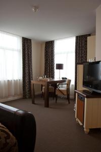 um quarto de hotel com uma mesa e uma televisão em Het Rechthuis em Uithoorn