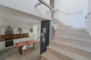 a staircase in a room with a table and a kitchen at Lemon house in Komin