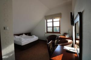 Niedrzwica KościelnaにあるHotel Marzannaのベッド、デスク、テーブルが備わる客室です。