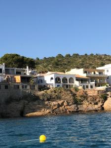 una bola amarilla en el agua frente a las casas en Hébergement front de mer en Sant Elm