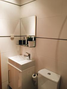 a bathroom with a sink and a toilet and a mirror at NEW APT center 1 min walk beach/river/casino!!! in Figueira da Foz