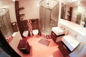 łazienka z 2 umywalkami, prysznicem i 2 toaletami w obiekcie Apartament Sandomierskie Wzgórze w mieście Sandomierz