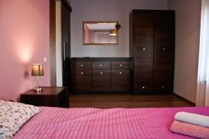 sypialnia z różowym łóżkiem z lustrem i komodą w obiekcie Apartament Sandomierskie Wzgórze w mieście Sandomierz