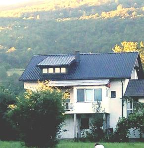 a house with a black roof on top of it at Apartment Mehi in Pazarić