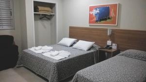 a hotel room with two beds with towels on them at Primavera Palace Hotel in Nova Andradina
