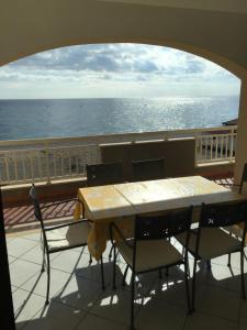 a table and chairs on a balcony with the ocean at Casa Vacanze Samira in Fondachello