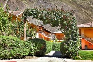 an arch of ivy in front of a building at Tunupa Lodge Hotel in Ollantaytambo