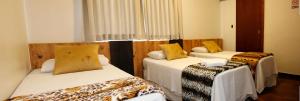 een kamer met drie bedden in een kamer bij Hotel Gaucha in Guaíra