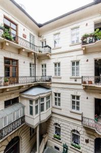 ブダペストにあるTamara Apartmanのバルコニーと窓が備わる白い大きな建物です。