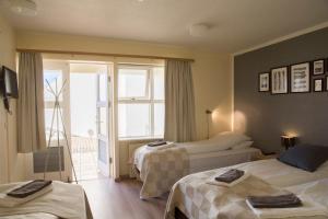 ヘプンにあるゲストハウス ハムールのベッド2台とバルコニーが備わるホテルルームです。