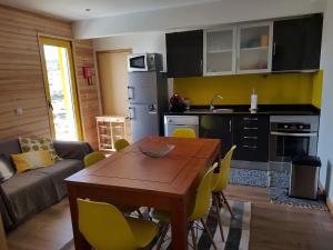 a kitchen and dining room with a table and yellow chairs at Casa da Bela Vista - Serra da Estrela in Covilhã