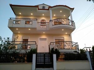 a large white house with two balconies on it at Prime Luxury Villa beach front in Nea Vrasna
