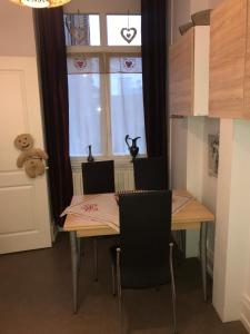 uma sala de jantar com uma mesa e cadeiras e uma janela em Coeur d'Elsass "RAPP"appartement avec parking em Colmar
