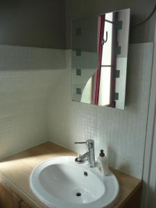 アルジュレス・ガゾストにあるGîte d'Ouroutのバスルーム(白い洗面台、鏡付)