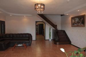 a living room with a couch and a staircase at Guest House Gold Oven in Cheboksary