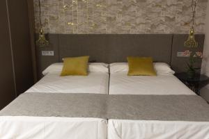 a bed with two pillows and a white comforter at Marbella Inn in Marbella
