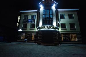 a building with a sign on the front of it at night at Guest House Gold Oven in Cheboksary