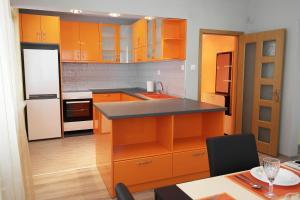 a kitchen with orange cabinets and a black counter top at Water House in Shumen