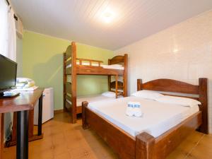 a bedroom with two bunk beds and a desk at Pousada Morada da Prainha in Caraguatatuba +29 photos