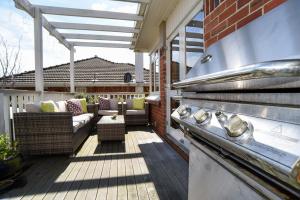 une terrasse avec un barbecue et du mobilier dans une maison dans l'établissement Sunny Mornington 2 Bedroom Guest Suite, à Dunedin