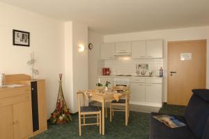 a living room with a table and a kitchen at Garni Hotel Hof zum Ahaus in Ahaus