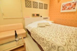 sypialnia z łóżkiem i butelką wina w obiekcie Restay Kitakami - Adult Only w mieście Kitakami