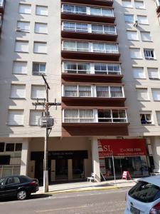 un edificio su una strada con auto parcheggiate di fronte di Edifício Torre de Prata a Torres