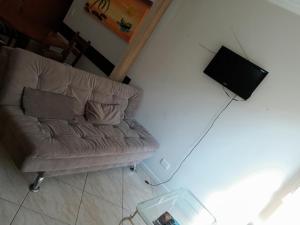 a living room with a couch and a television at Edifício Torre de Prata in Torres