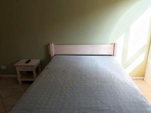 un letto in una camera con un tavolino di Edifício Torre de Prata a Torres